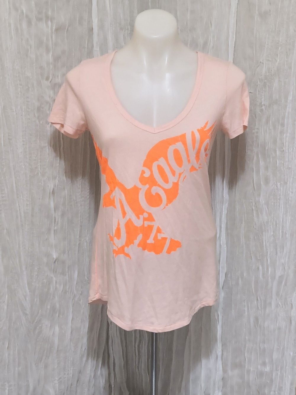 American Eagle Outfitters Pale Pink V‑Neck Tee with Neon Orange Graphic
